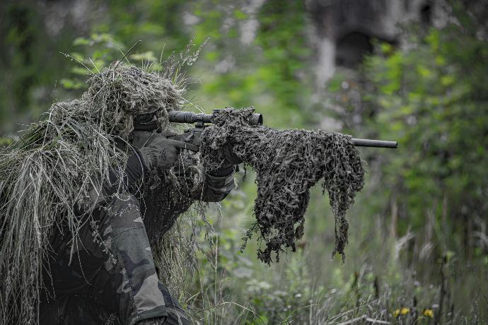 sniper wearing a ghillie in selective focus photography